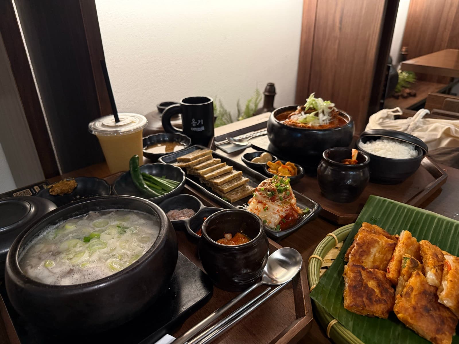 Onggii Novena Square 2 餐点:乳白牛骨汤、香辣炖牛肉、香蕉叶上的煎饼拼盘、自家泡菜与小菜。
