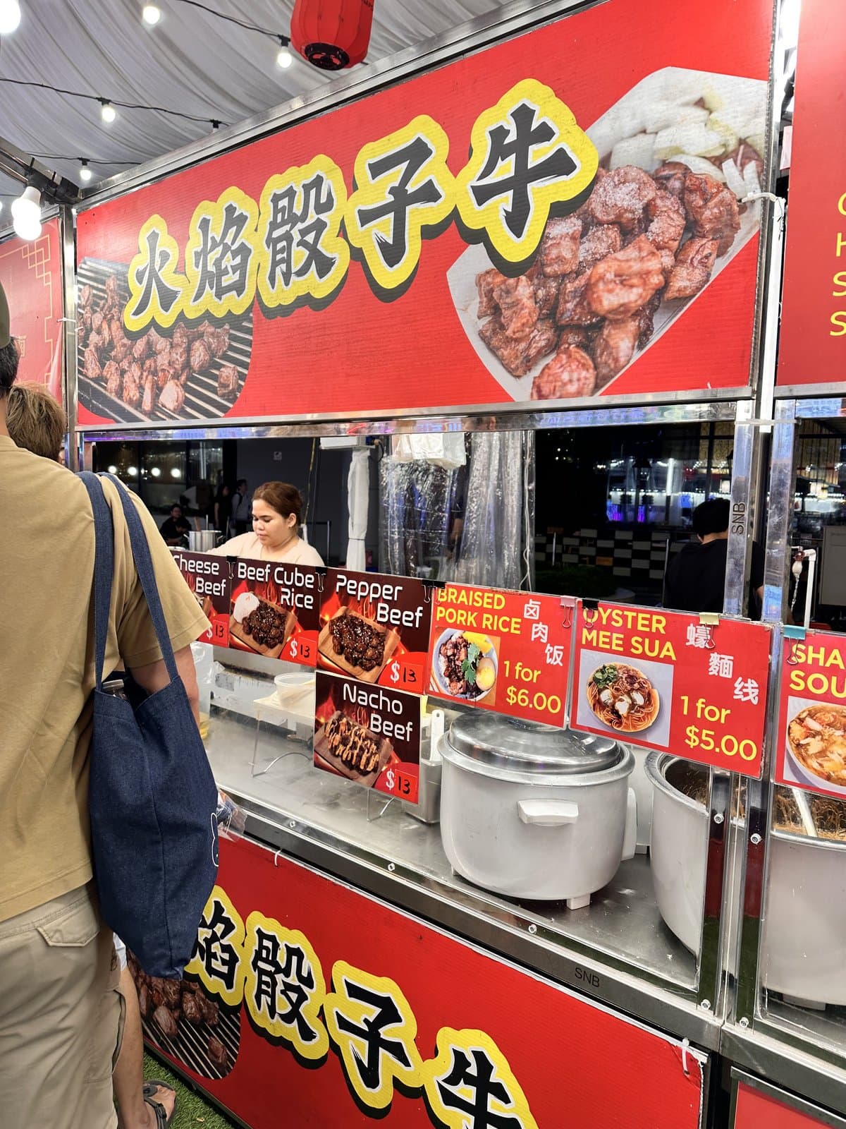 榜鹅 Waterway Point 台湾夜市的火焰骰子牛摊位 — 菜单显示滷肉飯 $6、蚵仔麵線 $5、胡椒牛等