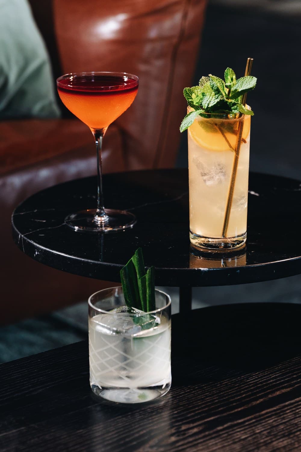 Lobby Bar 的两款国庆鸡尾酒 —— 一杯加薄荷的高身琥珀色调酒与一杯深红鸡尾酒 —— 摆在 The Warehouse Hotel 的桌上,旁边是限定 Warehouse Hotel x Bicycle 扑克牌。