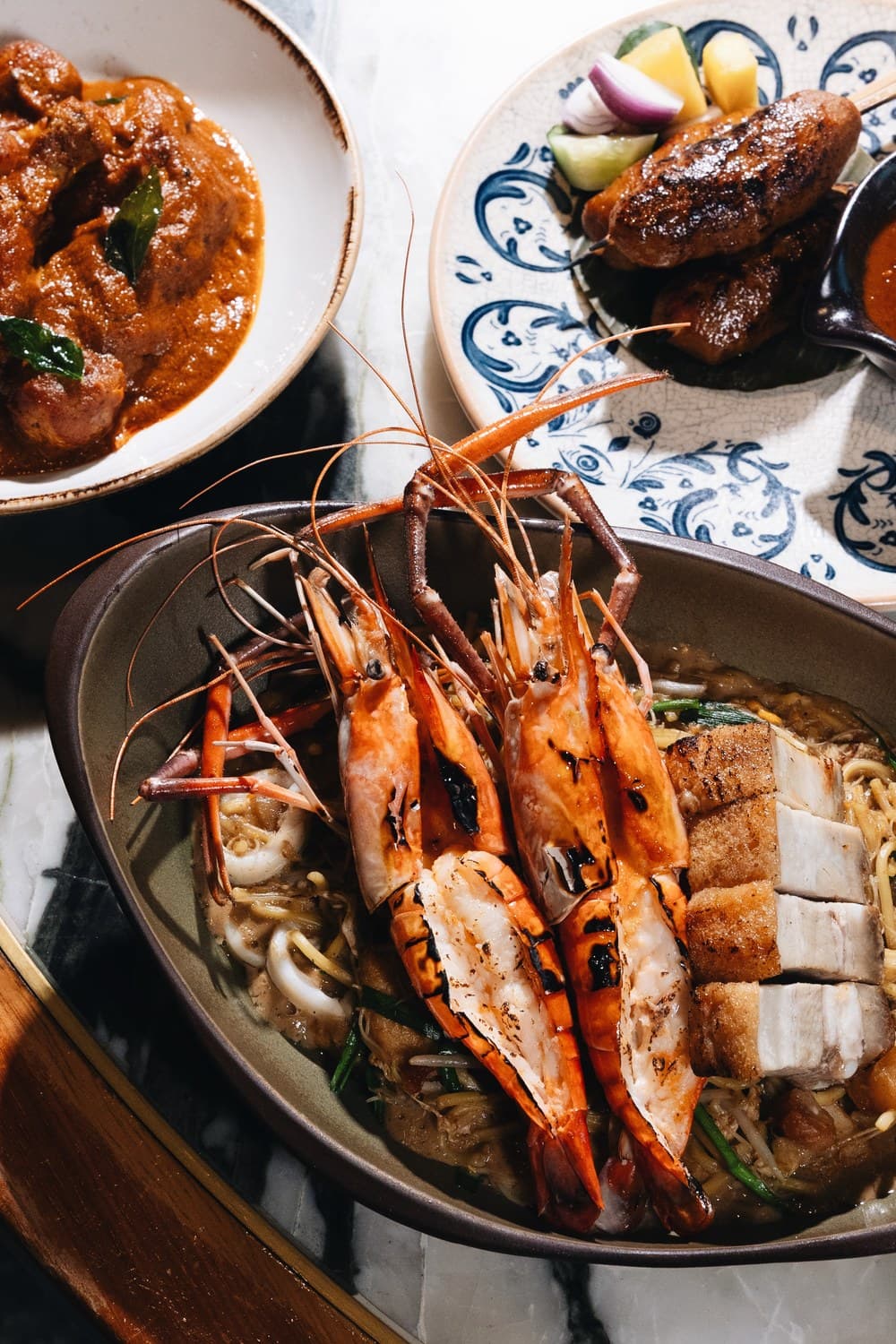 Po Restaurant 的国庆菜式 —— 顶着炭烤大河虾与烧肉的招牌虾福建面、一碗 Kari Ayam Kapitan 咖喱,以及沙爹串。