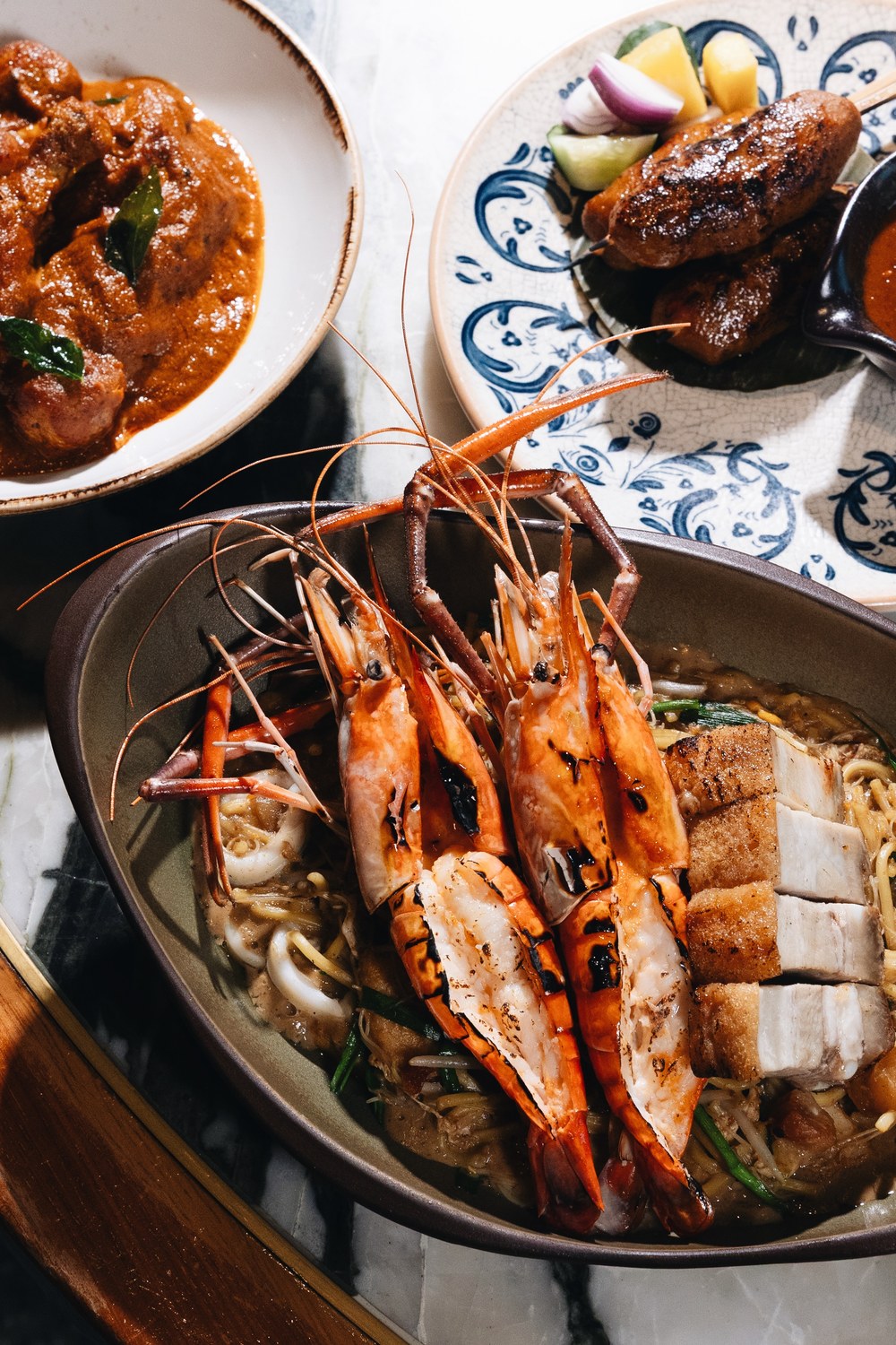 Po Restaurant 的国庆菜式 —— 顶着炭烤大河虾与烧肉的招牌虾福建面、一碗 Kari Ayam Kapitan 咖喱,以及沙爹串。
