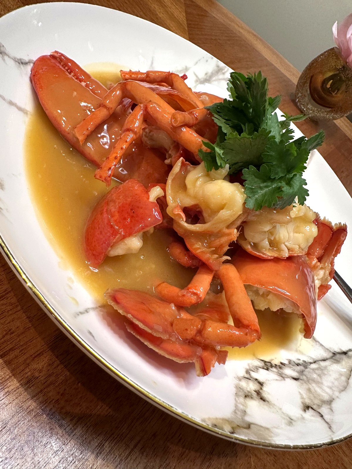 Boston Lobster in Superior Broth with Rice Noodles at Xin Cuisine, a whole 500g lobster in golden broth on a marble plate.