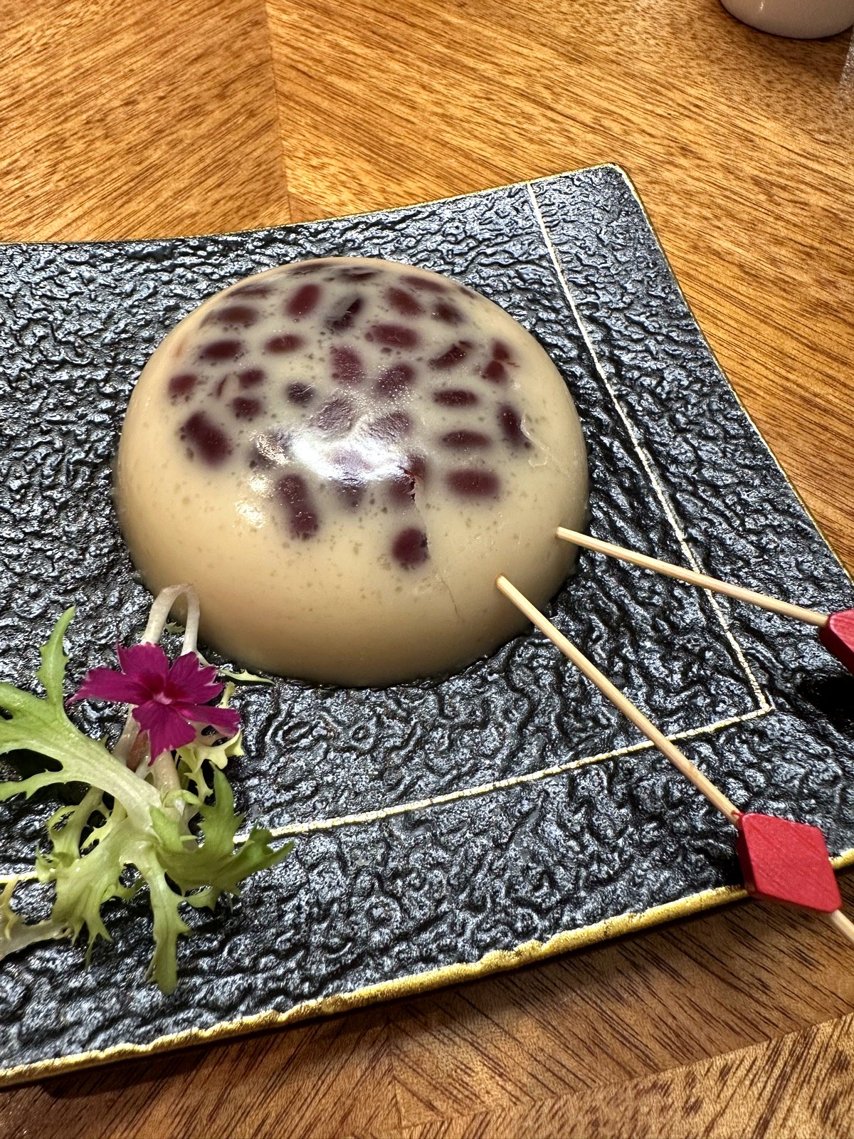 Red bean rice cake dessert at Xin Cuisine, a glossy dome studded with red beans.